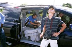 Controller Jake Anderson, in car, and Ryan Vu, manual pilot, both of Aerosonde, control the Weatherscout during a test flight at Northwest Field at Andersen Air Force Base, Guam, on Oct. 18.