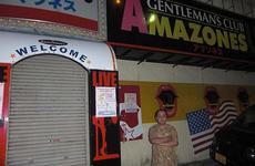 Tsutomu Arakaki, owner of Amazonesu, a club located on Gate 2 Street, outside Kadena Air Base, Okinawa, stands in front of his shuttered bar on Oct. 23, 2012.