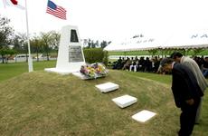 Ie Shima mayor Seitoku Shimabukuro and assembly head Hiroaki Uchima bow after placing bouquets of flowers at the Ernie Pyle Monument during a service commemorating the 60th anniversary of Pyle’s death.