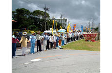 Protesters in front of a gate to MCAS Futenma hold hands during one of three successful rings around the air station Sunday during a demonstration observing the 32nd anniversary of Okinawa's reversion to Japan after World War II.