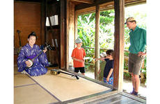 Tomiko Shimabukuro plays the sanshin for a family from Tokyo visiting Ryukyu Mura, a folk village sometimes referred to as Okinawa’s Williamsburg.