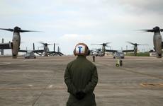 A Marine waits to guide MV-22 Ospreys with Marine Medium Tiltrotor Squadron 265, 31st Marine Expeditionary Unit, during their takeoff from Marine Corps Air Station Futenma, Okinawa.