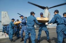 U.S. Marines assigned to the 31st Marine Expeditionary Unit and Japan Self Defense Force members transport supplies onto an MV-22B Osprey aboard the Japanese destoyer JS Hyuga, April 19, 2016.