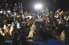People are seen at a parking lot in Mashiki, Kumamoto Prefecture, Japan, at 1:12 a.m. on Friday after evacuating their homes.
