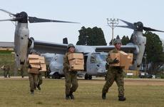 Soldiers from the Japan Ground Self-Defense Force unload emergency aid off a U.S. MV-22 Osprey at Hakusui Sports Park in Kumamoto, Japan, on Wednesday, April 20, 2016.
