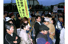 In this file photo from February 2008, demonstrators stand outside the Headquarters Gate of Camp Foster to protest the alleged rape of an Okinawan girl.