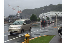 Vehicles make their way along slick roads at Yokosuka Naval Base, Japan, Wednesday, Sept. 9, 2015. U.S. bases experienced heavy rains due to Tropical Storm Etau, which caused floods and mudslides elsewhere in Japan.