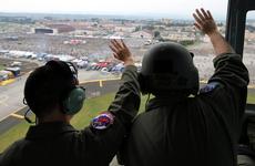 1st Lt. Kaleb Young and Tech. Sgt. Christopher Rector of the 459th Airlift Squadron wave to festivalgoers over Yokota Air Base, Japan, Sept. 17, 2016, during the Japanese-American Friendship Festival.