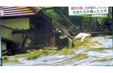 A screenshot of a TBS broadcast shows a home being destroyed by raging floodwaters in eastern Japan on Sept. 10, 2015.