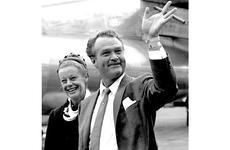 Comedian Red Skelton waves as he and his wife, Georgia, arrive in Tokyo in July, 1963.