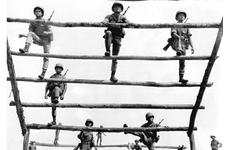 It's up and over the ladder on the rugged 100-yard infiltration course for South Vietnamese army recruits at the 18th ARVN Training Center near Gia Rai, 52 miles northeast of Saigon.