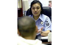 Navy Counselor 1st Class Neilyn Dionisio gives career advice to a young sailor at Yokosuka Naval Base.