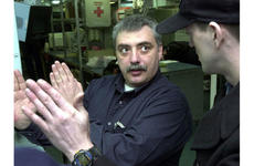George Webb, a civilian technical representative of Northrop Grumman, talks about an electronics system for Naval aircraft with Petty Officer 3rd Class Timothy Russell aboard the USS Kitty Hawk.