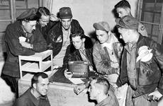 In Korea, F-86 Sabre pilots and other personnel of the 4th Fighter-Interceptor Wing listen to election returns over Armed Forces Radio Service in November 1952.