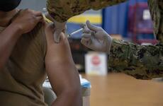 A sailor receives the coronavirus vaccine at Naval Base San Diego’s Adm. James Prout gymnasium in January 2021.