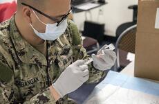 A sailor prepares a Moderna COVID-19 vaccine at Naval Air Facility Atsugi, Japan, May 7, 2021.