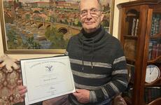 A retired U.S. Army major holds a certificate signed by President Joe Biden.