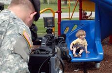 Pfc. Joseph Tolliver films James Ernst, 4, sliding on the playground for an upcoming AFN spot on summer safety. Armed Forces Network personnel in Vicenza, Italy, produce 15-20 spots a month on a variety of topics, helping fill in the gaps between the shows on AFN.