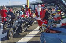 Bikers dressed as Santa gather at a highway rest stop in Ebina, Japan, to deliver hundreds of toys that will be donated to Japanese children's homes, Sunday, Dec. 5, 2021.