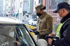 Pvt. Daija Gillam, 22, of the 25th Transportation Battalion, screens drivers before allowing them to enter Camp Walker in the coronavirus-hit city of Daegu, South Korea, Saturday, Feb. 22, 2020.