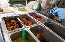 A culinary specialist checks the temperature of chicken wings.