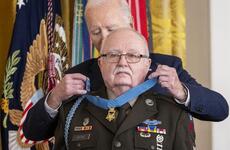 Joe Biden places the Medal of Honor around the neck of an elderly man in military dress uniform.