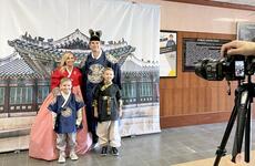 A U.S. soldier and his family pose for a photo while wearing traditional Korean clothing.