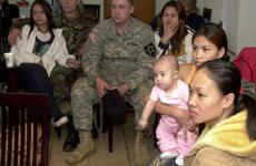 Wives and and a few of their family members listen to speakers at a foreign spouses’ monthly meeting at the Camp Casey United Service Organizations building.