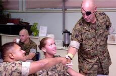 Clebe McClary, a Marine veteran who was severely wounded during the Vietnam War, shakes hands with Marines at the USO on Camp Hansen, Okinawa, on Friday.
