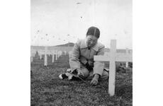 A Korean woman pulls weeds among the gravesites.