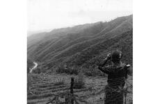 A platoon leader with the 1st Republic of Korea Division looks through a set of binoculars toward North Korea from his position in the Demilitarized Zone. 