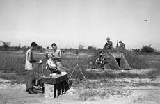 Capt. Earle Yeamans examines an infantryman’s teeth as his fellow soldiers look on.