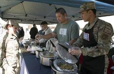 USO volunteers serves single service members a free Thanksgiving meal at Yokota Air Base, Japan, Tuesday, Nov. 22, 2022.
