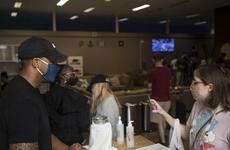 A volunteer from the 374th Airlift Wing's security forces squadron, left, works the front desk for the USO at Yokota Air Base, Japan, Saturday, July 11, 2020.