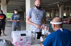 A service member receives a coronavirus test kit within hours of arriving at Osan Air Base, South Korea, Tuesday, July 14, 2020.