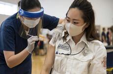 Fire inspector Kaede Miura receives her first dose of the Moderna COVID-19 vaccine at Yokosuka Naval Base, Japan, Friday, June 18, 2021.