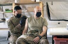 Sgt. Maj. John Shannon receives the COVID-19 vaccine from Sgt. Ryan Kamanu, a medic with the 466th Medical Company Area Support, at the the Role II medical facility at Al Asad Air Base, Iraq, on March 15, 2021.