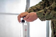 A sailor sanitizes his hands before entering the Navy Exchange at Yokosuka Naval Base, Japan, Aug. 13, 2020. 