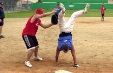 A Warriors player crosses home plate doing a handstand during last week’s successful attempt by members of the 2nd Infantry Division to break the world record for longest continuous softball game. The game lasted 100 hours and ended Saturday.