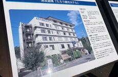 A sign displays Japanese writing and a photo of a multi-story hotel.