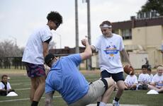 Atlanta Falcons defensive end Morgan Fox is helped to his feet during a youth football camp.