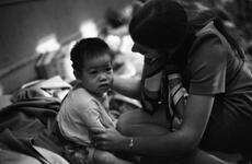 A young child is held by a woman.