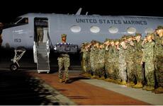 Marines saluting as remains are transported.