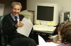 A man smiles at a woman in an office.