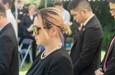 People dressed in black bow their heads during a memorial service.