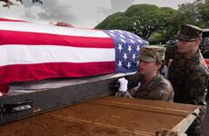 A transfer case containing Korean War remains is loaded into a truck.