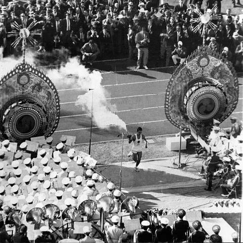 Yoshinori Sakai, the Olympic flame torchbearer, runs to light the Olympic cauldron