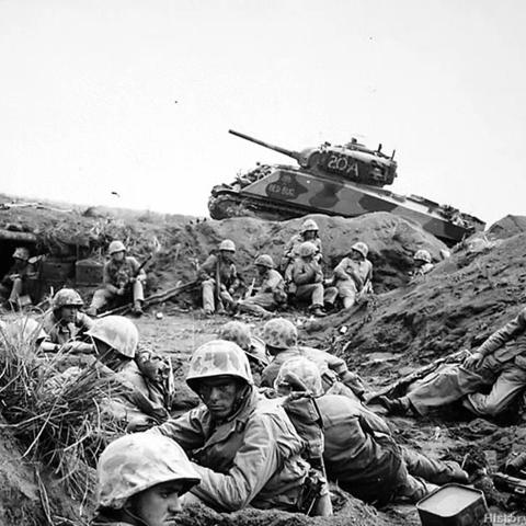 Marines in a ditch with a tank in the background