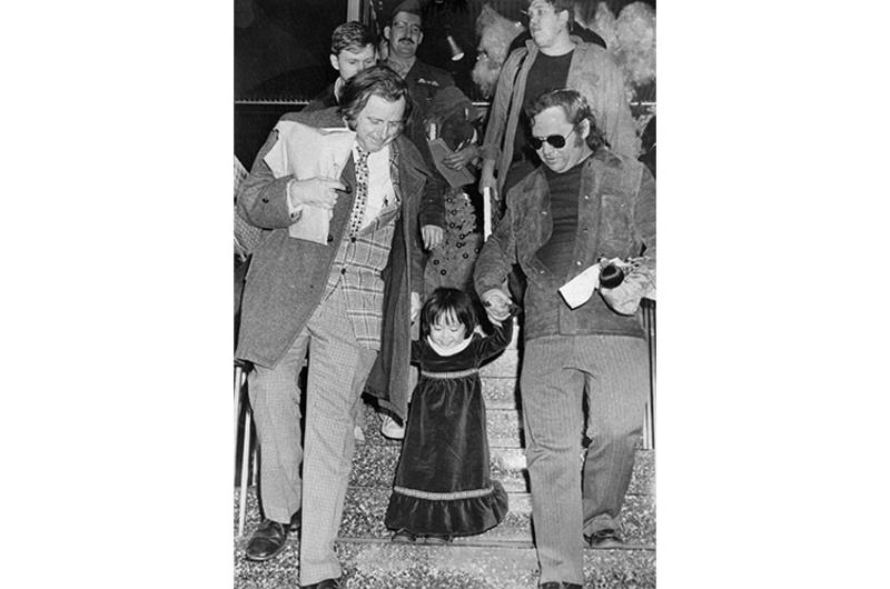 A beaming Kim Yon Jin - now Jenny Jones - is led down a stairway at Tokyo International Airport Tuesday by Pacific Stars and Stripes Hal Drake (left) and Jim Lea.