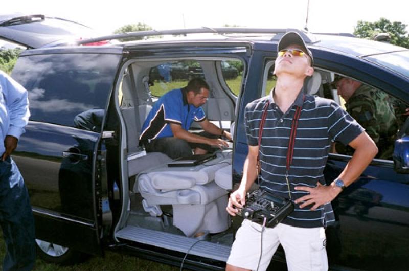 Controller Jake Anderson, in car, and Ryan Vu, manual pilot, both of Aerosonde, control the Weatherscout during a test flight at Northwest Field at Andersen Air Force Base, Guam, on Oct. 18.